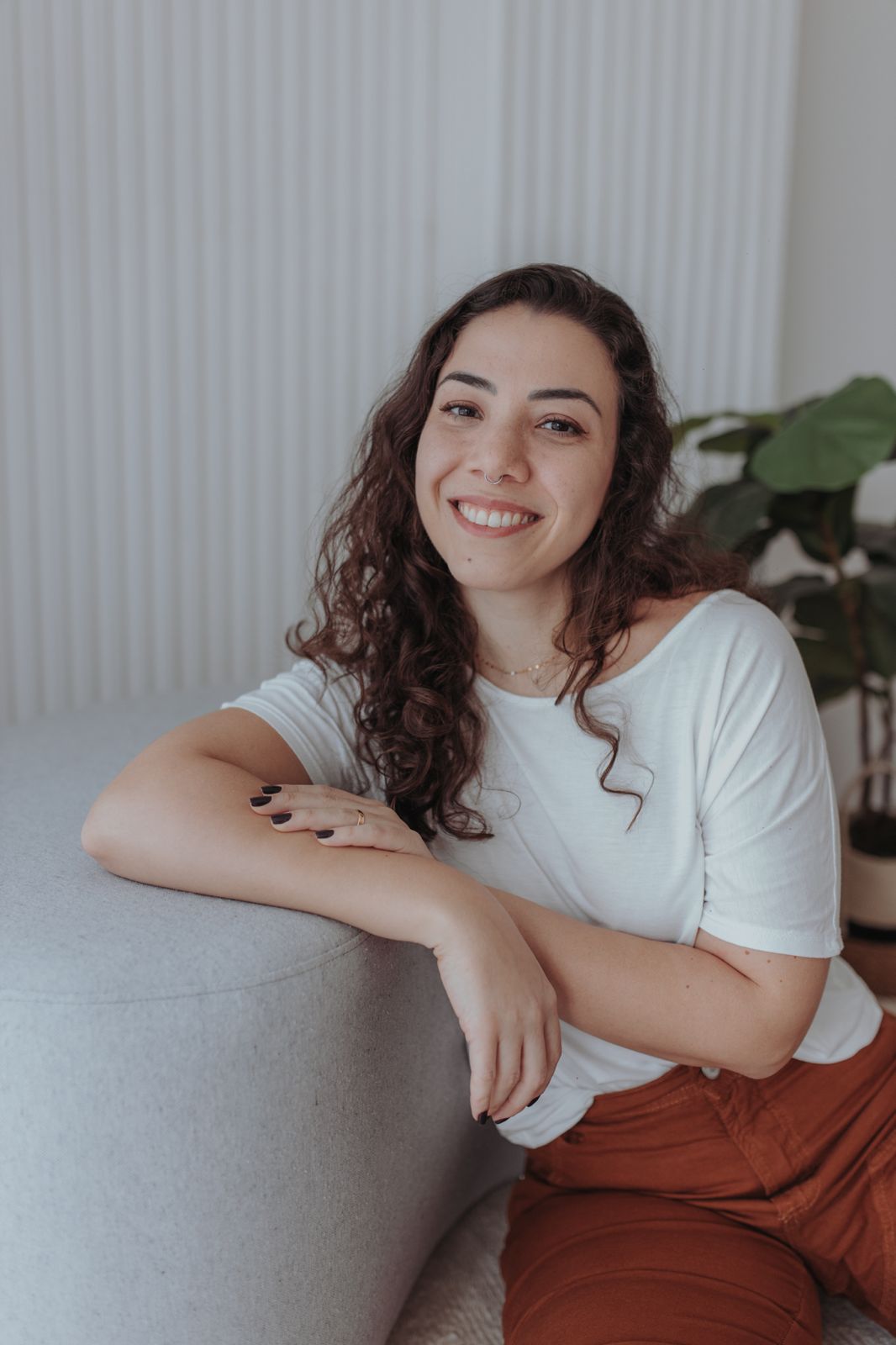 Psicóloga Andressa Moro sorrindo em um ambiente acolhedor.